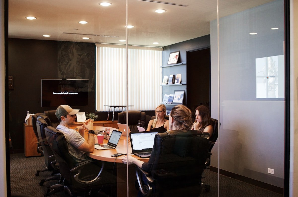 Consultants meeting with a client around a laptop